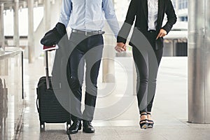 Businessman and Businesswoman Dragging suitcase luggage bag, walking to passenger boarding in Airport. Couple of love travel to