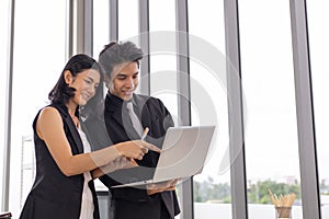 Businessman and businesswoman meeting, discussing and working together with laptop