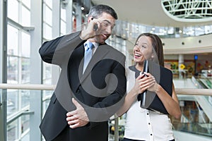 Businessman and businesswoman on mobile phones