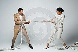 businessman and businesswoman pulling rope on