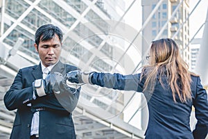Businessman and businesswoman punching in the city