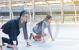 The businessman and businesswoman ready to run on start position with challenge and commitment to success