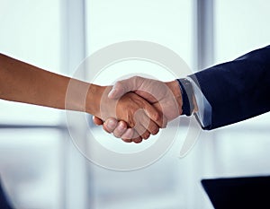 Businessman and businesswoman shake hands on agreement.