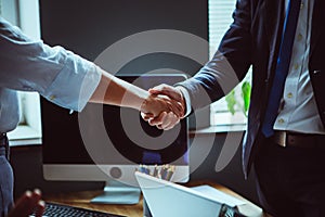 Businessman and businesswoman shake hands after team brainstorming. Close up shot of male and female hands against of