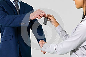 Businessman and businesswoman shaking hands in agreement holding car keys