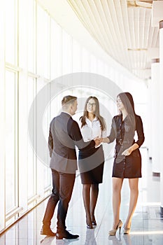 Businessman And businesswoman shaking hands In bright Office