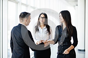 Businessman And businesswoman shaking hands In bright Office