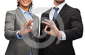 Businessman and businesswoman showing ok sign