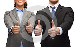 Businessman and businesswoman showing thumbs up