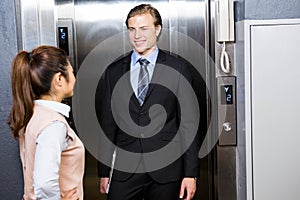 Businessman and businesswoman standing in an elevator