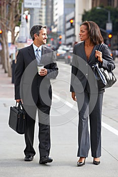 Businessman And Businesswoman In Street With Takeaway Coffee