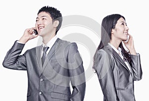 Businessman and businesswoman talking on cell phone