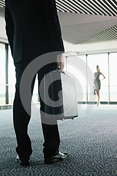 Businessman and businesswoman waiting for their flight in airport lounge. Conceptual image shot