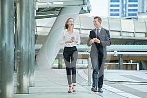 Businessman and businesswoman walking and talking on  street in city Outside Office with ,young couple discussing and eating