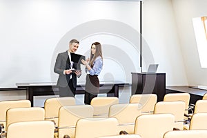 Businessman and businesswoman working in meeting hall