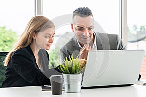 Businessman and businesswoman working in office.