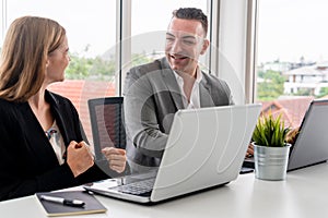 Businessman and businesswoman working in office.