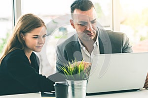 Businessman and businesswoman working in office.