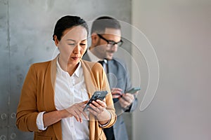 Businessman and businesswoman working and using smart mobile phones on meeting in corporate office