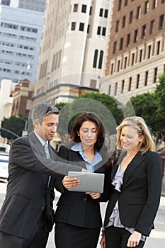 Businessman And Businesswomen Using Digital Tablet Outside