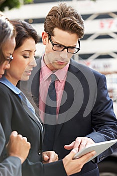 Businessman And Businesswomen Using Digital Tablet Outside