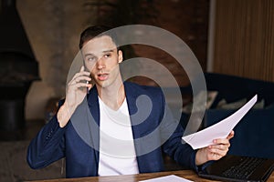 Businessman busy working on laptop computer with mobile smart phone on desk