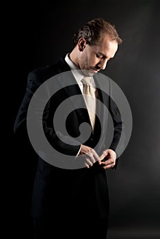 Businessman buttoning jacket, getting dressed.