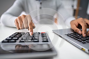 Businessman Calculating Expense In Office