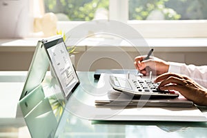 Businessman calculating invoice using calculator