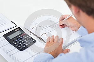 Businessman calculating tax in office photo