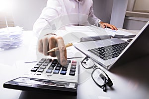 Businessman Calculating Tax Using Calculator