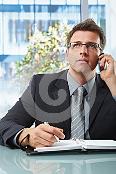 Businessman on call taking notes