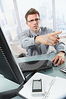 Businessman calling and gesturing in office