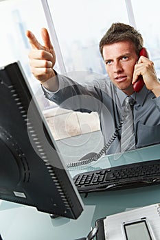 Businessman calling and gesturing in office