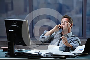 Businessman calling on landline at office photo