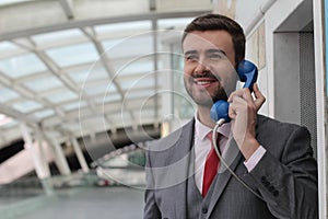 Businessman calling by public phone at the airport