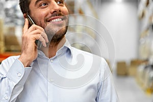 businessman calling on smartphone at warehouse