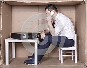 Businessman calmly negotiating on the phone, sitting in a small corporate office