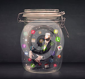 Businessman captured in a glass jar with colourful app icons con