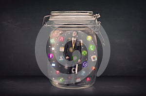 Businessman captured in a glass jar with colourful app icons con