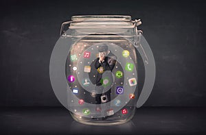 Businessman captured in a glass jar with colourful app icons con