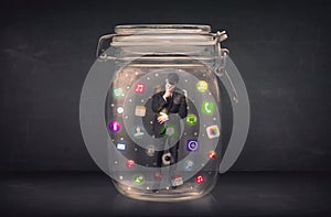 Businessman captured in a glass jar with colourful app icons con