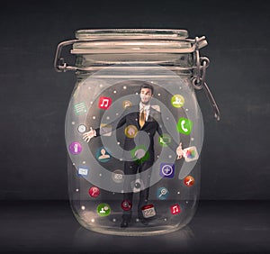 Businessman captured in a glass jar with colourful app icons con