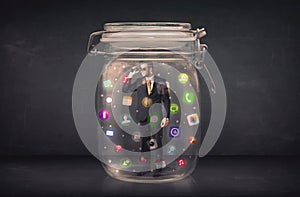 Businessman captured in a glass jar with colourful app icons con