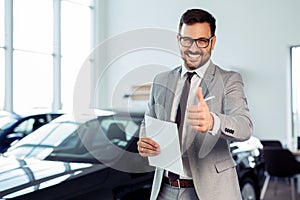 Businessman in a car dealership - sale of vehicles to customers