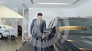 Businessman in a car salon. Man looking at the car