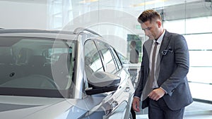 Businessman in a car salon. Man looking at the car