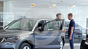 Businessman in a car salon. Man looking at the car