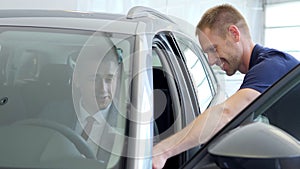 Businessman in a car salon. Man looking at the car