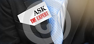 Businessman with a card with text Ask the Expert in upper suit pocket. Business concept